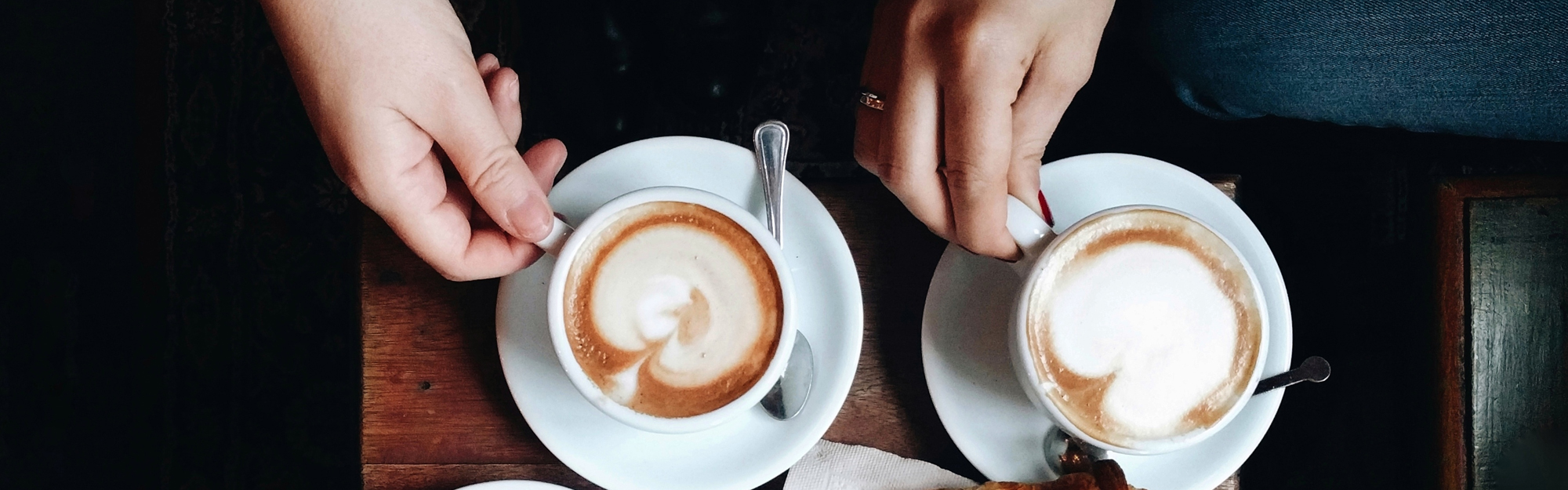 Två persioner sitter med varsin kaffe latte på ett café