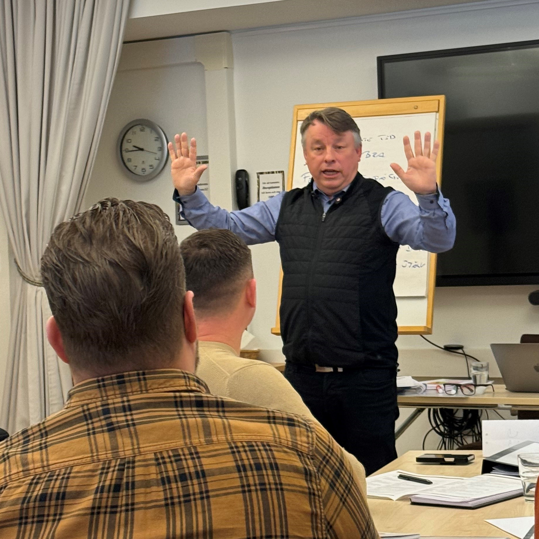 En man står och gestikulerar i undervisningslokalen